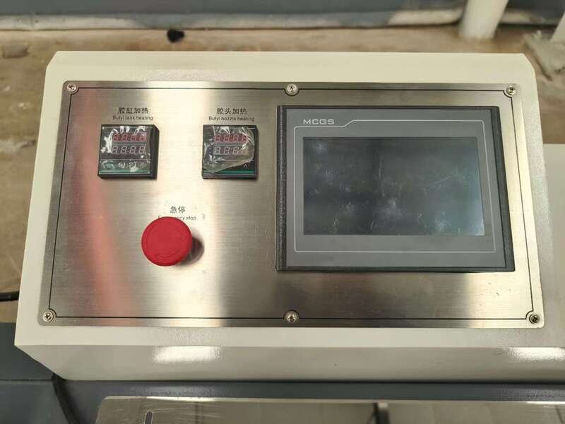 Advanced safety system in an automatic butyl extruder, featuring emergency stop functions and protective enclosures for secure IGU production.